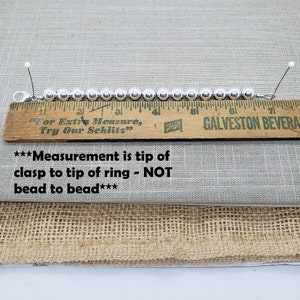 Pode incluir: Um bracelete de prata com contas redondas medido com uma r&eacute;gua de madeira. A r&eacute;gua diz "For Extra Measure, Try Our Schlitz" e "GALVESTON BEVERA". O texto abaixo da r&eacute;gua diz "***Measurement is tip of clasp to tip of ring - NOT bead to bead***".