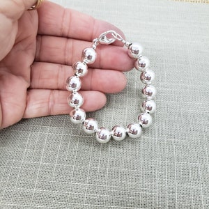 Pode incluir: Um bracelete de prata com grandes contas redondas. O bracelete &eacute; feito de prata de lei e tem um fecho de lagosta.