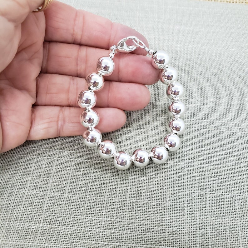 Pode incluir: Um bracelete de prata com grandes contas redondas. O bracelete &eacute; feito de prata de lei e tem um fecho de lagosta.