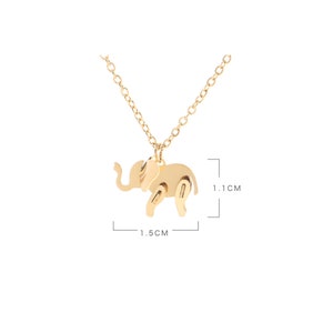 May include: Gold-colored elephant pendant necklace. The elephant charm is 1.5 cm long and 1.1 cm high. The necklace has a delicate chain and a simple design. The elephant has cut-out details.