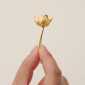 May include: A gold-colored flower hair clip with a delicate stem and a single flower head.