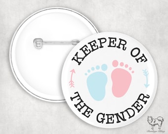 Könnte beinhalten: Weißer Knopf mit schwarzem Text, der "Keeper of the Gender" lautet, mit einem blauen und einem rosa Fußabdruck auf jeder Seite des Textes. Es gibt rosa und blaue Pfeile, die auf die Fußabdrücke zeigen.