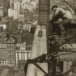 Puede incluir: Dos trabajadores de la construcción en un edificio de gran altura, uno está sentado en una viga, el otro está colgado de una cuerda, mirando hacia abajo a la ciudad.