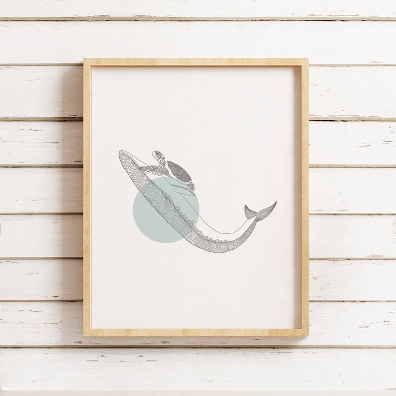 May include: A framed print of a line drawing of a whale with a turtle on its back. The whale is swimming through a light blue circle. The print is on a white background.
