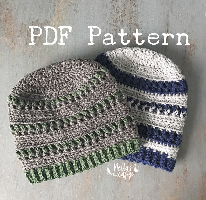 May include: Two crocheted hats, one gray with green stripes and one white with blue stripes. The hats are on a gray wooden surface. The text "PDF Pattern" is at the top of the image.