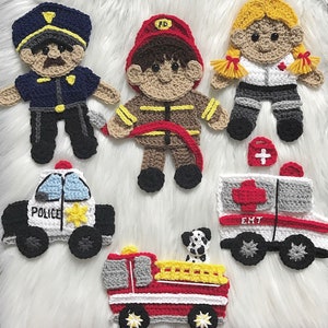 Może przedstawiać: Dzianinowe figurki z filcu przedstawiające policjanta, strażaka, ratownika medycznego i dalmatyńczyka. Figurki trzymają samochód policyjny, wóz strażacki i karetkę. Wszystkie figurki są ubrane w mundury i mają przyjazne twarze.