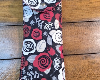 Estuche para gafas artesanal con rosas rojas y blancas y cierre magnético.