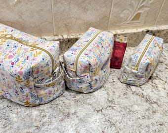 Set de cosméticos o artículos de aseo de viaje hechos a mano con estampado floral primaveral en color lavanda.