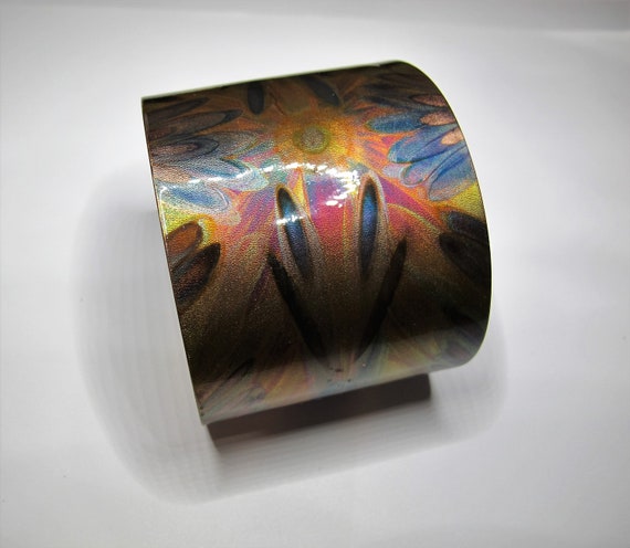 Flame painted copper bracelet. The cuff is flame painted with a torch and covered by a protective coat