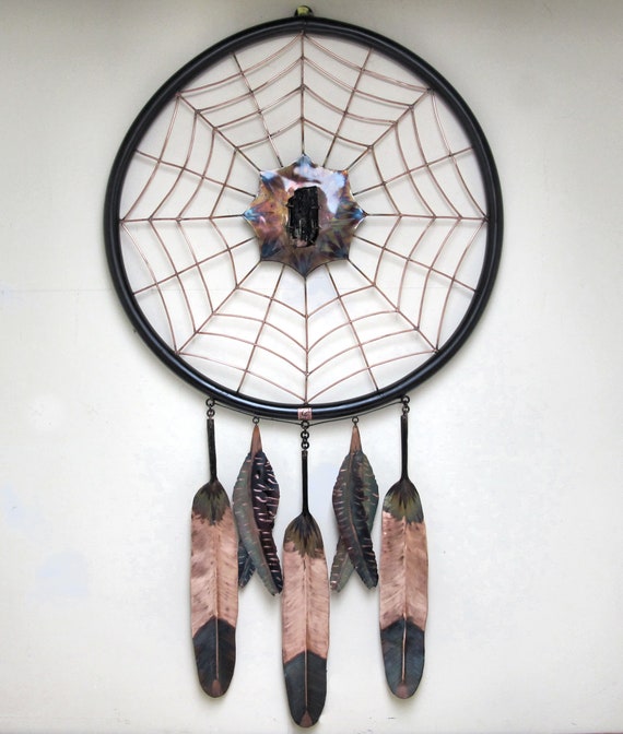 Giant sculpture of a copper dream catcher. The copper is torch-colored and has received several layers of copper protection.