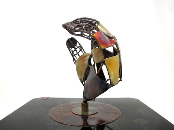 The hand is a sculpture made of wires and pieces of copper. The copper is torch-colored and has two layers of clear coat for protection.