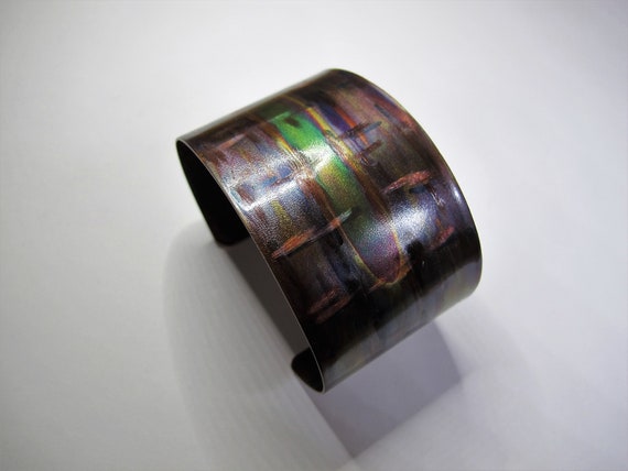 Flame painted copper bracelet with blowtorch in shades of green. The color was produced by the flame of the torch.