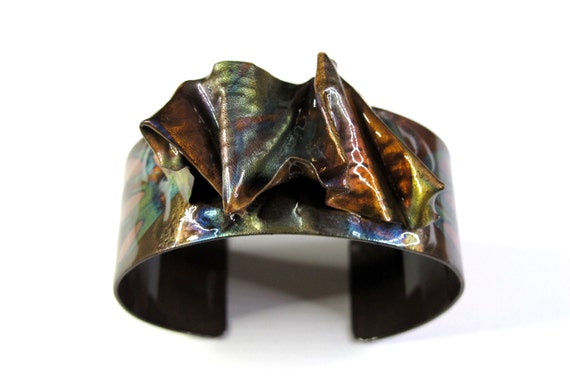 Copper Bracelet was hammered and texturized, free style. The cuff is flame painted with a torch and covered by a protective coat