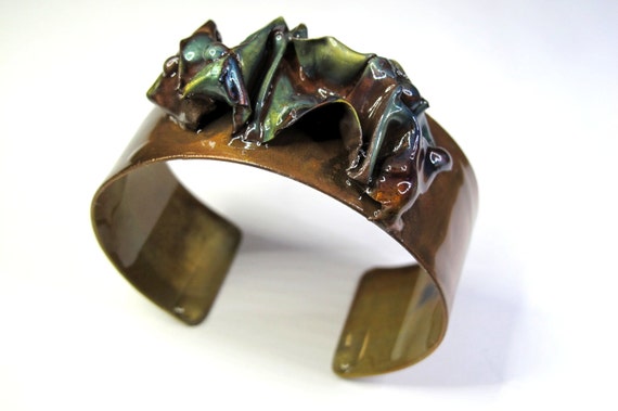 Copper Bracelet was hammered and texturized, free style. The cuff is flame painted with a torch and covered by a protective coat