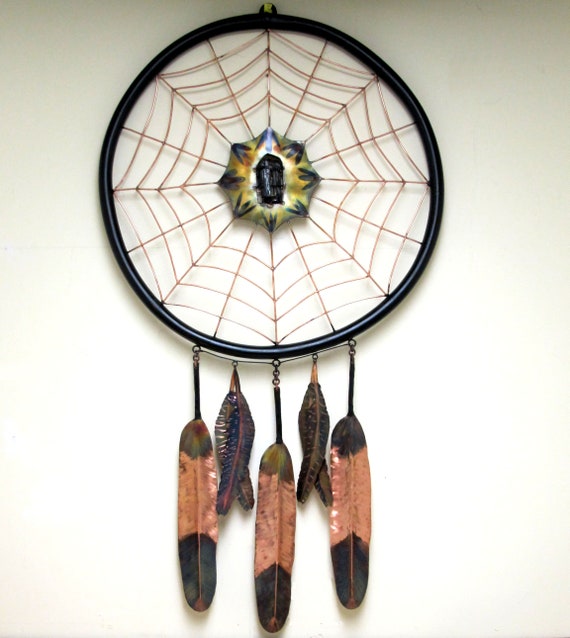Giant sculpture of a copper dream catcher. The copper is torch-colored and has received several layers of copper protection.