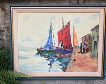 May include: Oil painting of a harbor scene with sailboats. The boats have red, blue, and orange sails. The painting is framed in a green and gold frame. Figures stand on the dock near buildings with green and red walls. The water reflects the boats.