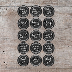 Puede incluir: Un conjunto de 15 pegatinas redondas en blanco y negro con varios mensajes, incluyendo "¡Gracias por comprar en pequeño!" y "¡Hecho a mano con amor!"