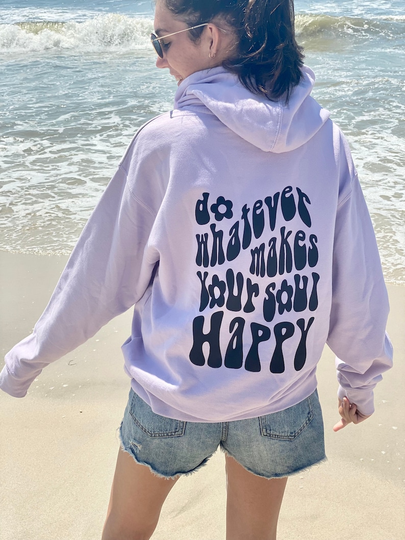 May include: A lavender hoodie with a black graphic on the back that says "do whatever makes your soul happy" in a retro font.