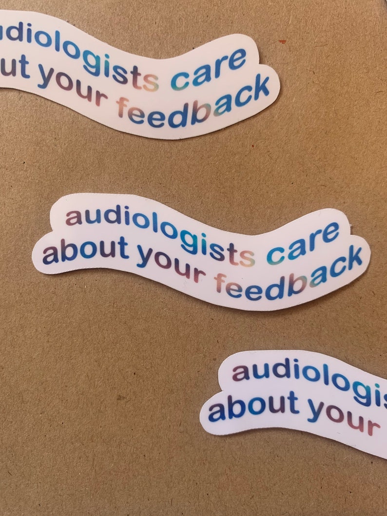 Op de afbeelding: Drie witte stickers met een blauwe, groene en roze gradi&euml;nt. De stickers hebben de tekst "audiologists care about your feedback" erop.