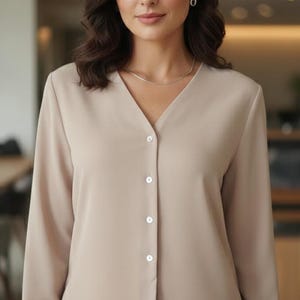Blusa casual estilo anos 80 com ombros acolchoados e botões de madrepérola, estilo vintage para escritório.