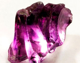 May include: A large, faceted amethyst crystal with a deep purple hue. The crystal has a unique, irregular shape with many facets.