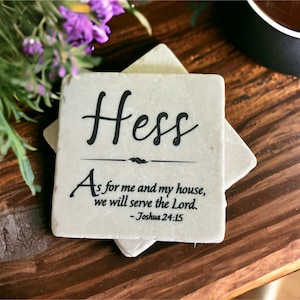 May include: Two white square coasters with a black inscription. The top coaster has the name "Hess" and the quote "As for me and my house, we will serve the Lord. - Joshua 24:15".