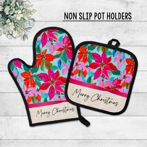 May include: A non-slip oven mitt and pot holder set. The set features a floral design with red, pink, and orange flowers on a light blue background. The words "Merry Christmas" are printed on a pink ribbon.