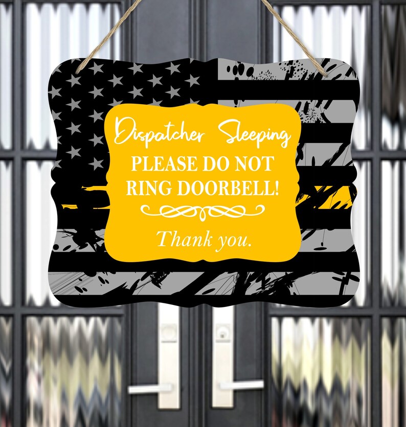 May include: A yellow sign with black and gray stripes and a thin yellow stripe across the top. The sign reads "Dispatcher Sleeping Please Do Not Ring Doorbell! Thank you."