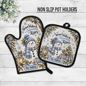 May include: A non-slip oven mitt and square pot holder set featuring a snowman wearing a blue plaid scarf and hat. The design includes pine branches, lanterns, gifts, snowflakes, and the text Warm Wishes & Snowman Kisses and The Millers.