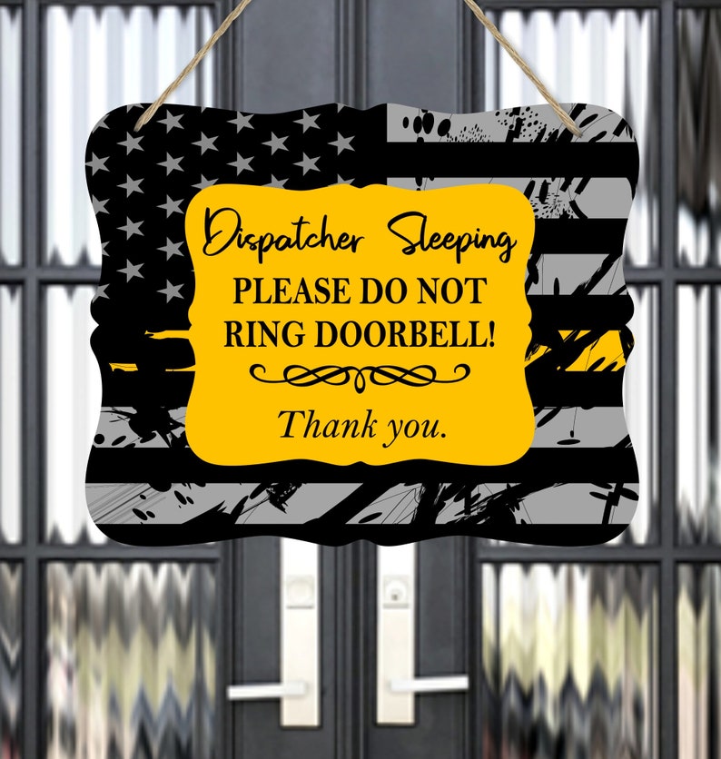 May include: A yellow and black sign with a thin yellow stripe across the top and the text "Dispatcher Sleeping Please Do Not Ring Doorbell! Thank you." on a yellow background.