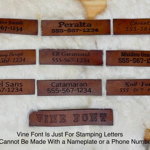 May include: A collection of brown leather nameplates with various font styles, each displaying a name and phone number. The fonts include Berkshire Swash, Peralta, Caveat Font, Dancing Script, EB Garamond, Maiden Orange, Martel Sans, Catamaran, and Sail Font.