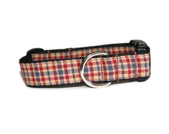 May include: A red, blue, and tan plaid dog collar with a black buckle and silver D-ring.