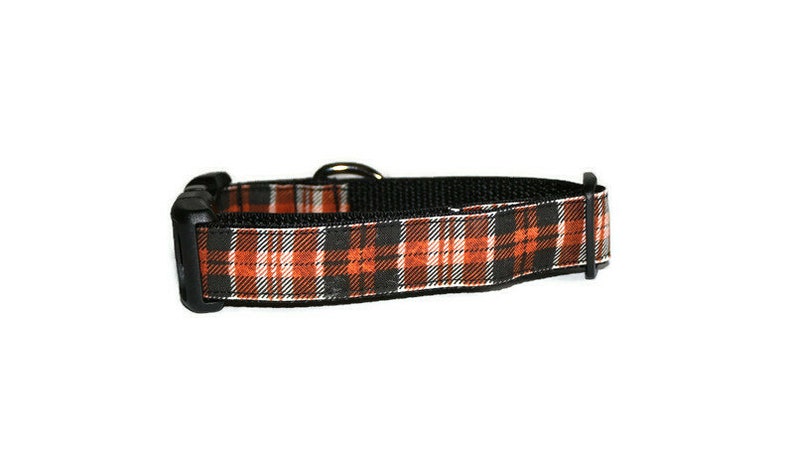 May include: A black and orange plaid dog collar with a black buckle.