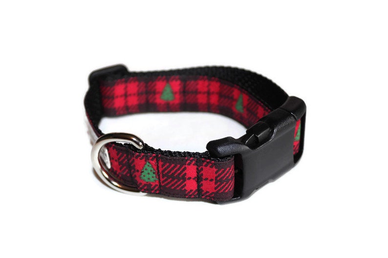 May include: A red and black tartan dog collar with a green Christmas tree pattern and a black plastic buckle.