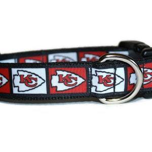 May include: A black dog collar with a red, white, and black pattern featuring the Kansas City Chiefs logo.
