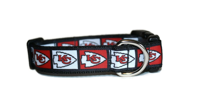 May include: A black dog collar with a red, white, and black pattern featuring the Kansas City Chiefs logo.