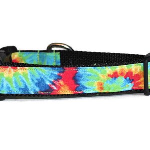 May include: A black dog collar with a tie-dye pattern in shades of blue, green, red, and yellow.
