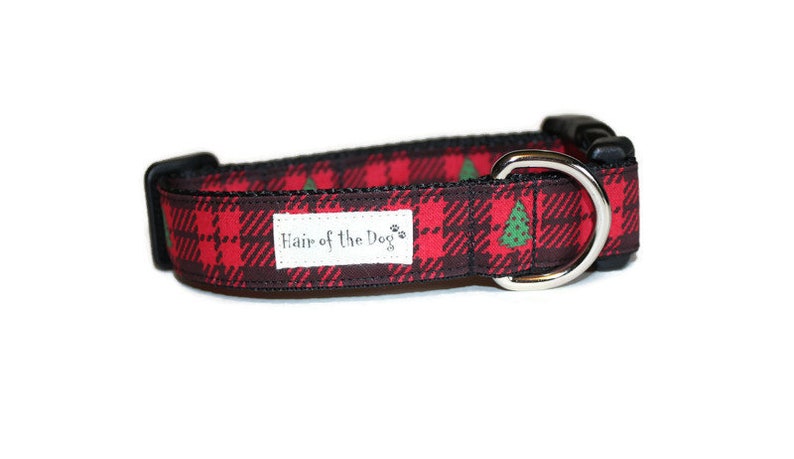 May include: Red and black plaid dog collar with green Christmas trees and the text "Hair of the Dog" on a white label.