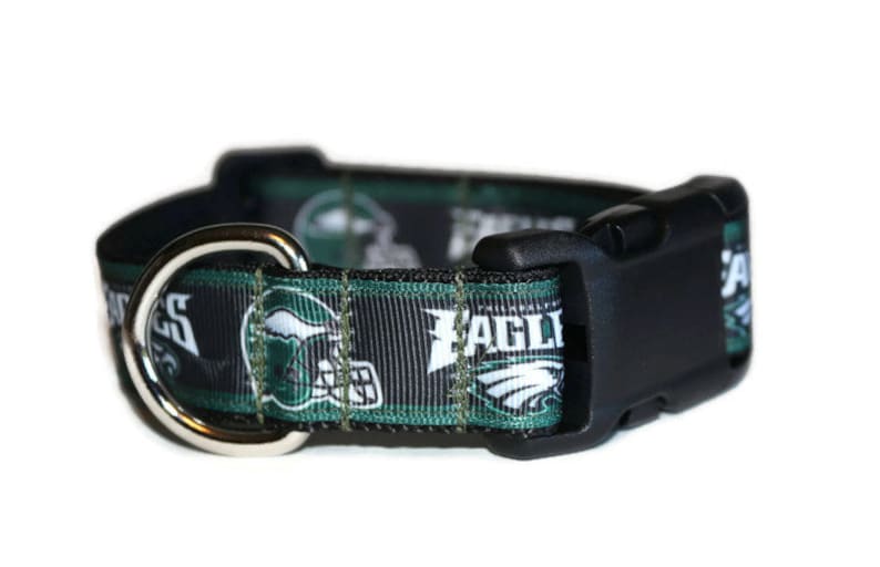 Puede incluir: Collar para perro negro y verde con un logotipo de los Philadelphia Eagles y la palabra "Eagles" impresa en &eacute;l. El collar tiene un anillo en D plateado y una hebilla de pl&aacute;stico negra.