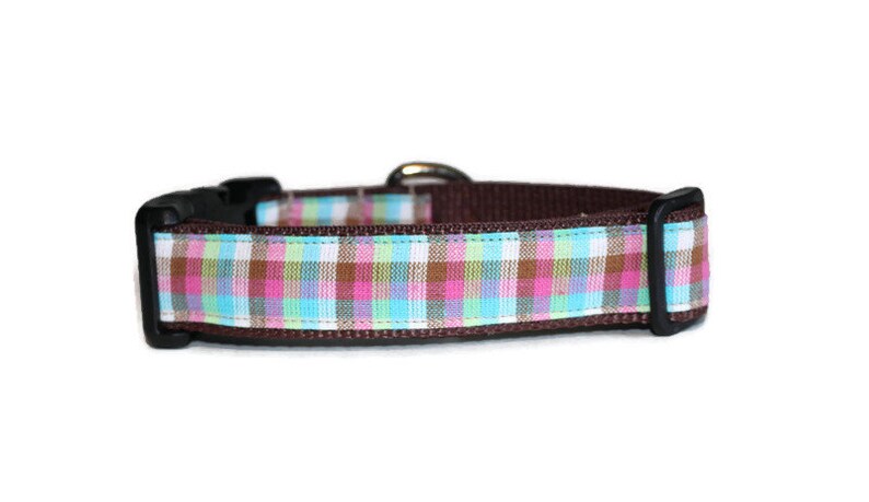 May include: A brown dog collar with a pink, blue, and green plaid pattern.