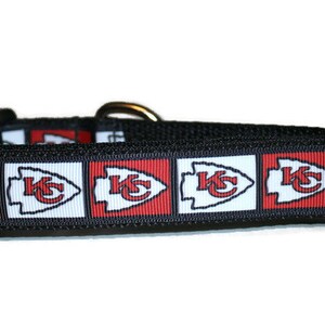 May include: Black dog collar with a red, white, and black pattern featuring the Kansas City Chiefs logo.