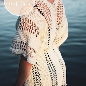 May include: A white crochet top with a lacy open back design. The top has a V-neck and short sleeves.