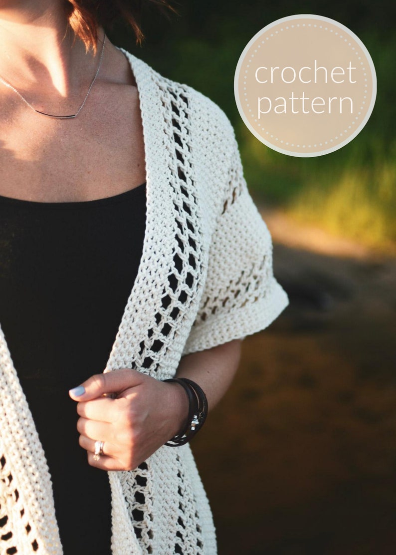 May include: A white crochet cardigan with a delicate openwork pattern. The cardigan is open in the front and has short sleeves.