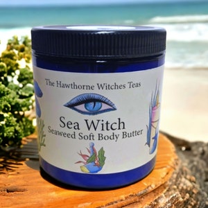 May include: A blue jar with a white label that reads "The Hawthorne Witches Teas Sea Witch Seaweed Soft Body Butter". The label features a blue eye with eyelashes and a seaweed design.