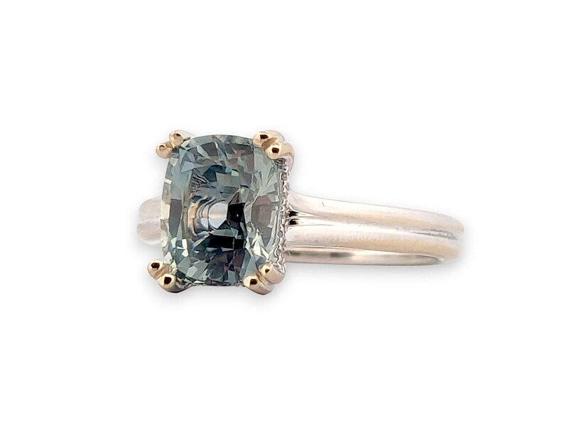 K&ouml;nnte beinhalten: Ein goldener Ring mit einem quadratischen, gr&uuml;nen Edelstein. Der Ring hat eine schlichte Band und der Edelstein ist von einer goldenen Umrandung umgeben.