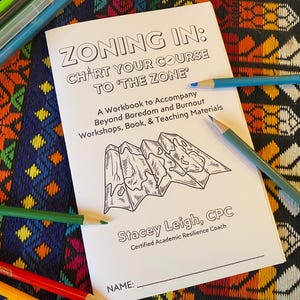 May include: A black and white workbook titled "Zoning In: Chart Your Course to 'The Zone'" with a drawing of a folded map. The subtitle reads "A Workbook to Accompany Beyond Boredom and Burnout Workshops, Book, & Teaching Materials". The author is Stacey Leigh, CPC, Certified Academic Resilience Coach. There is a blank line for a name.