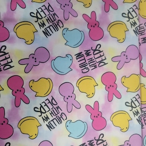 May include: Fabric with a repeating pattern of cartoon marshmallow chicks and bunnies in pink, yellow, and blue on a tie-dye background. The text "Chillin' with my Peeps" is also printed on the fabric.