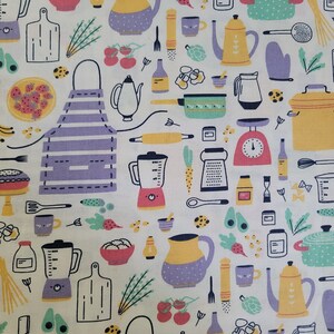 May include: A white fabric with a repeating pattern of kitchen-themed illustrations. The design includes blenders, cutting boards, teapots, pots, aprons, and various food items in a colorful, cartoon style.