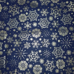 May include: A dark blue fabric featuring a repeating pattern of metallic gold snowflakes and starburst designs. The intricate, geometric snowflake shapes vary in size and style, creating a dense, festive, and symmetrical visual texture across the surface.