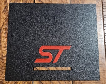 May include: Black car dashboard insert with a red "ST" logo.